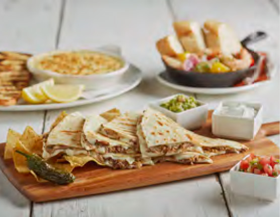 Appetizers laid out including quesadillas, queso dip and more